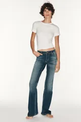 Jeans de tiro bajo y diseño bootcut, con efecto lavado, trabillas y cinco bolsillos clásicos. Cuenta con cierre frontal de cremallera y botón metálico.