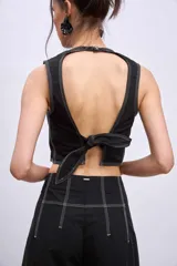 Blusa crop top negra sin mangas con cuello redondo y pespuntes blancos contrastantes.