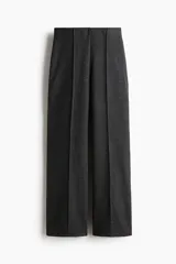 Pantalón de corte holgado confeccionado en punto fino de mezcla de algodón. Presenta un diseño de tiro alto con elástico oculto en la cintura y pliegues cosidos en la parte frontal.