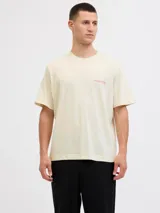Camiseta de manga corta y cuello redondo, color blanco antiguo (off-white), con un estampado gráfico grande en la espalda que simula una fotografía urbana nocturna con un taxi amarillo y texto en tipografía cursiva y recta.