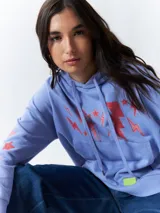 Canguro blanco de manga larga y capucha, con estampa de rayos en tonos rosa, verde y amarillo en el frente y las mangas.