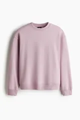 Buzo de cuello redondo color rosado, con hombros caídos y diseño holgado.