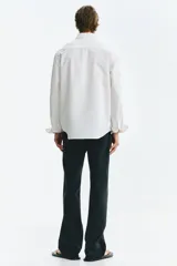 Camisa Oxford de algodón blanca, de corte regular fit, con cuello americano, bolsillo frontal aplicado y mangas largas con puños abotonados.