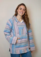 Buzo con capucha de tejido grueso a rayas horizontales en tonos pastel: celeste, rosa y gris. Tiene bolsillo tipo canguro y cordones ajustables en el cuello.