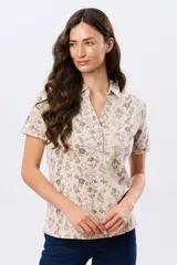 Camisa de algodón de manga corta en tejido jersey, con estampado floral de inspiración retro, cuello camisero y abertura frontal parcial con botones.