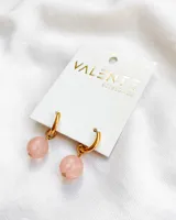 Aros tipo argolla pequeña de acero dorado con dije colgante de piedra natural esférica en tono rosado.