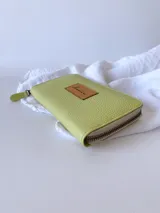 Billetera grande de cuero color verde lima con cierre metálico y monedero interno.