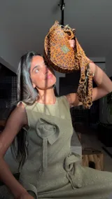 Bandolera de cuero con estampado animal print de leopardo, forma de media luna y correa ajustable.