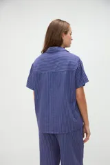Camisa de manga corta de algodón con diseño a rayas en tonos amarillo y blanco, calce holgado, cuello solapa y bolsillo aplicado en el pecho.