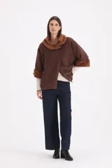 Saco de paño color marrón con cuello y puños de piel sintética al tono. Presenta un diseño de corte recto con cierre frontal de un solo botón.