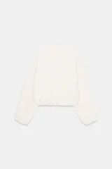 Chaqueta de corte corto y diseño abullonado en color marrón oscuro, con cuello solapa, mangas largas con puños elásticos y cierre frontal con cremallera metálica. Cuenta con bolsillos delanteros de doble vivo.
