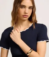 Top de manga corta ajustado al cuerpo, color marrón oscuro, con cuello redondo y bordes festoneados en color crema o beige claro.