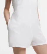 Enterito corto color blanco hueso, con escote en V, breteles anchos y bolsillos laterales.