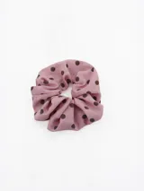 Colita para el pelo tipo scrunchie de tela rosada con estampado de lunares marrones.