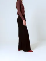 Pantalón de corte sastrero y pierna ancha, color negro, con cintura alta y pinzas frontales.