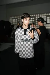 Casaca unisex de manga larga, con cuello tejido negro y estampado a cuadros en blanco crudo y negro.