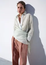 Pantalón de corte recto y tiro medio con diseño de rayas, confeccionado en mezcla de lino y viscosa. Cuenta con detalle de pinzas, trabillas y cierre frontal con cremallera, botón y ganchos ocultos con tapeta.