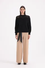 Pantalon de vestir negro de corte recto y tiro alto, con cintura ancha y cinto de lazo integrado en la misma tela.