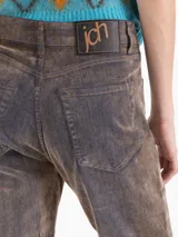 Pantalón de corte oxford con silueta ajustada hasta la rodilla y botamanga relajada. Confeccionado en tela Denim Velvet con textura aterciopelada y acabado de jean lavado en tono marrón.