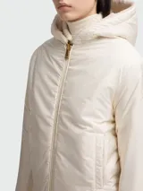 Buzo con capucha de tejido afelpado color beige claro, con cierre frontal de cremallera y bolsillos canguro. Presenta puños y bajo acanalados.