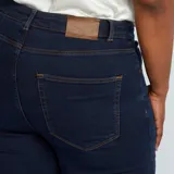 Pantalón de jean skinny de tiro alto, color azul oscuro, con cinco bolsillos y cierre frontal con botones.