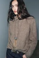 Chaqueta de punto confeccionada en lana, con cuello subido, manga larga y cierre frontal con botones. Presenta un acabado con efecto cepillado.