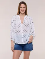 Blusa holgada de gasa texturizada color blanco con estampado de lunares negros, escote en V con botones frontales, mangas 3/4 abullonadas y puños elásticos.
