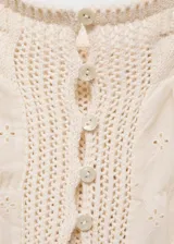Top de tirantes finos con diseño combinado de tejido de punto y tela con detalles calados. Presenta cierre frontal de botones y corte recto con escote.