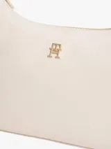 Cartera Tommy Hilfiger de poliuretano color beige, con cierre superior de cremallera, asa corta y correa extraíble. Cuenta con el monograma metálico de la marca en el frente.