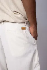 Bermuda de lino color beige, de corte recto y diseño minimalista con bolsillos laterales.