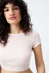 Top corto negro de punto acanalado con escote redondo, mangas cortas y ribetes blancos en cuello y mangas.