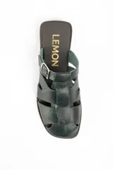 Zueco tipo cangrejera de cuero lavado color verde oscuro, con diseño de tiras entrelazadas y hebilla metálica lateral ajustable.
