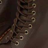 Botas de cuero estilo militar con cordones, modelo 1460 de Dr. Martens. Presentan un acabado en cuero Crazy Horse de aspecto envejecido, costuras amarillas características en la vira y suela de goma AirWair resistente.