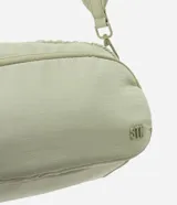 Bolso bandolera de estilo deportivo en color verde claro, confeccionado en poliéster. Cuenta con cierre principal de cremallera, bolsillo frontal con cierre, bolsillo trasero con cierre a presión, asa larga desmontable y regulable, y logo de la marca en relieve en la parte frontal.