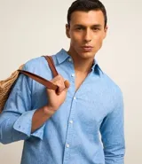Camisa comfort masculina de lino y algodón color celeste, con cuello inglés, manga larga y abotonado delantero.