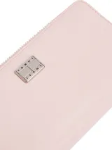 Billetera Tommy Jeans color rosa con cierre de cremallera, logo metálico plateado en el frente y correa de muñeca negra.