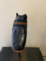 Mocasín de cuero color beige con textura reptil, detalle de tira ancha horizontal y suela de madera.