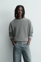 Sweater relaxed fit de canalé, color negro con efecto lavado, cuello redondo y manga larga con acabados en rib.