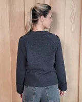 Cardigan de lana lambswool con diseño color block en tonos beige, marrón y turquesa. Presenta escote en V, cierre frontal con botones y puños anchos acanalados.