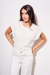 Remera blanca de algodón con textura de puntos calados horizontales, corte al cuerpo y mangas cortas tipo mariposa.