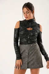 Polera negra con lurex, cuello alto, mangas largas y aberturas en hombros y pecho.