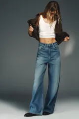 Jeans de tiro alto con corte wide leg y pernera recta. Presentan un diseño de cinco bolsillos con efecto lavado y cierre frontal mediante cremallera y botón metálico.