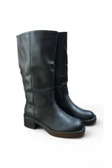 Bota alta de cuero sintético negro, con caña slouchy y taco cuadrado de altura media con plataforma.