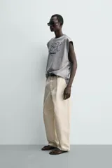 Camiseta sin mangas de corte relajado, color gris melange, con cuello redondo y estampa bordada en contraste en el frente.