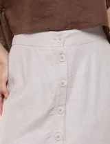 Falda midi evasé de mezcla de lino color beige, con abotonadura frontal completa, pretina elastizada en la espalda, pespuntes horizontales en contraste y terminación bordada en el ruedo. Incluye forro interior.