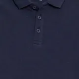 Chomba lisa de piqué azul marino, corte clásico, con cuello y puños acanalados, y tapeta con tres botones.