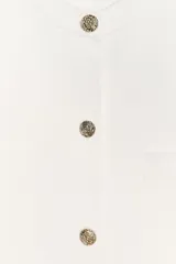 Chaqueta de punto color amarillo pálido, con cuello redondo, manga corta, cierre frontal con botones dorados y bolsillos de parche en el pecho.