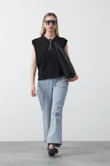 Remera sin mangas negra con hombros marcados y caída recta.