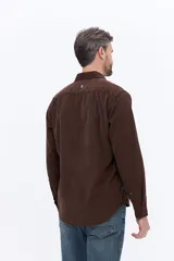 Camisa de pana de algodón con cuello clásico, cierre frontal de botones y mangas largas. Presenta un diseño de corte regular con textura suave y acabado mate.