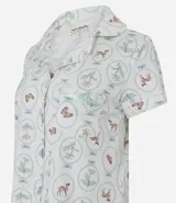 Conjunto de pijama de dos piezas, compuesto por una blusa de manga corta con cuello solapa, cierre frontal de botones y bolsillo en el pecho, y un short con cintura elástica y lazo de satén. El tejido es viscolycra con estampado de motivos florales y mariposas en círculos.